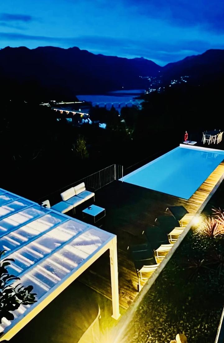 Piscine à débordement au crépuscule, vue sur la vallée et le lac